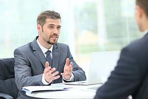 a man working for a Sales Consulting Firm handing a sales consulting firm talking with client