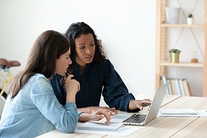 two women working on computer with Manager working with a Sales Consulting Firm