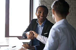 a man with experience in sales shaking hands with client