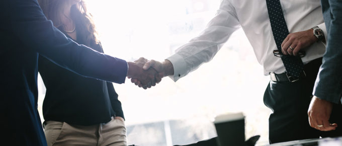 two people shaking hands after agreeing to sales management training